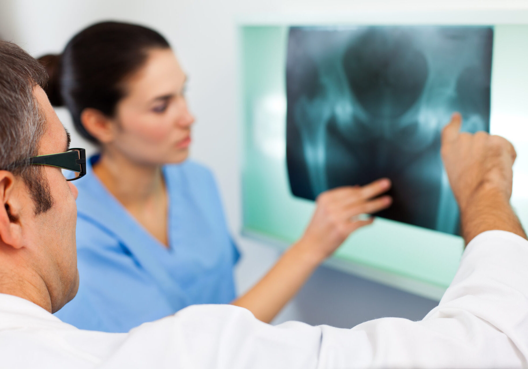 Medical team examining X-ray image of a pelvis in the hospital.